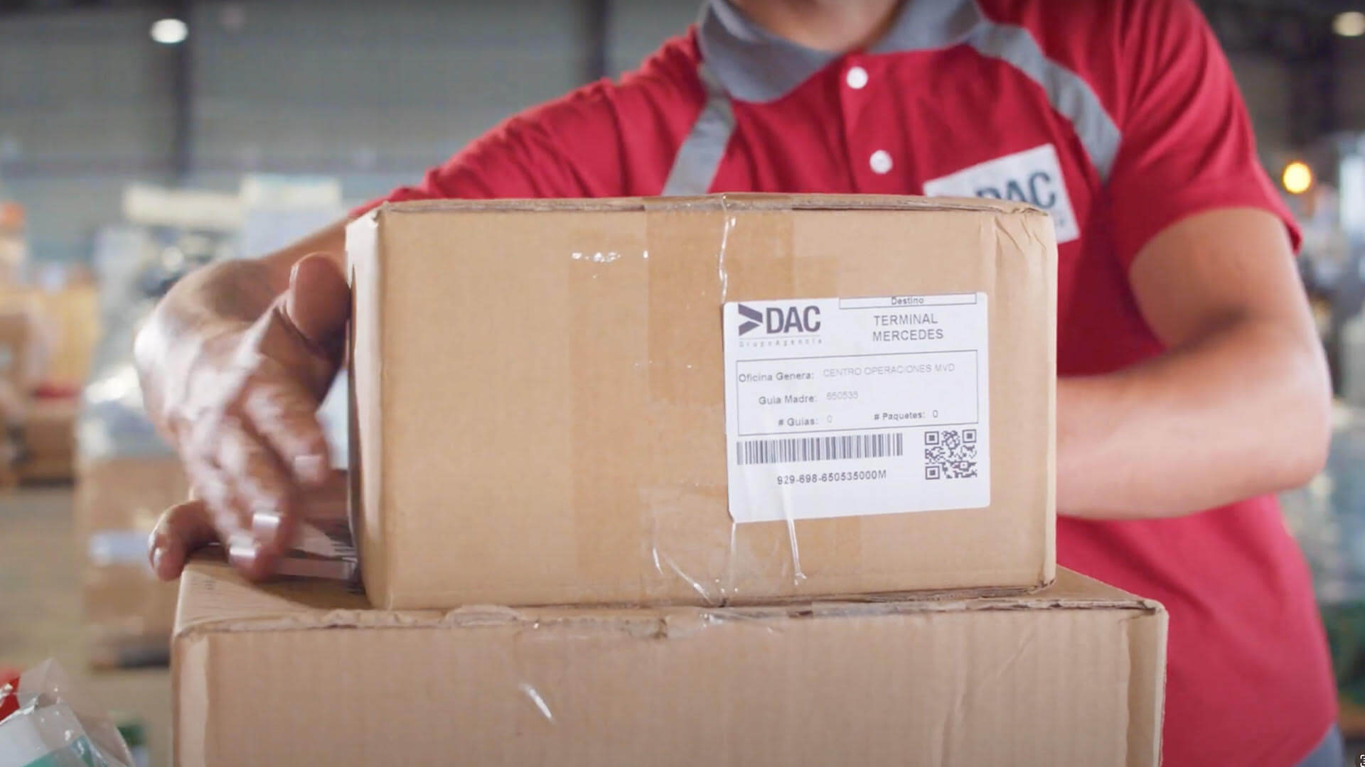 Empleado de DAC agarrando un paquete para ser enviado mediante correo privado