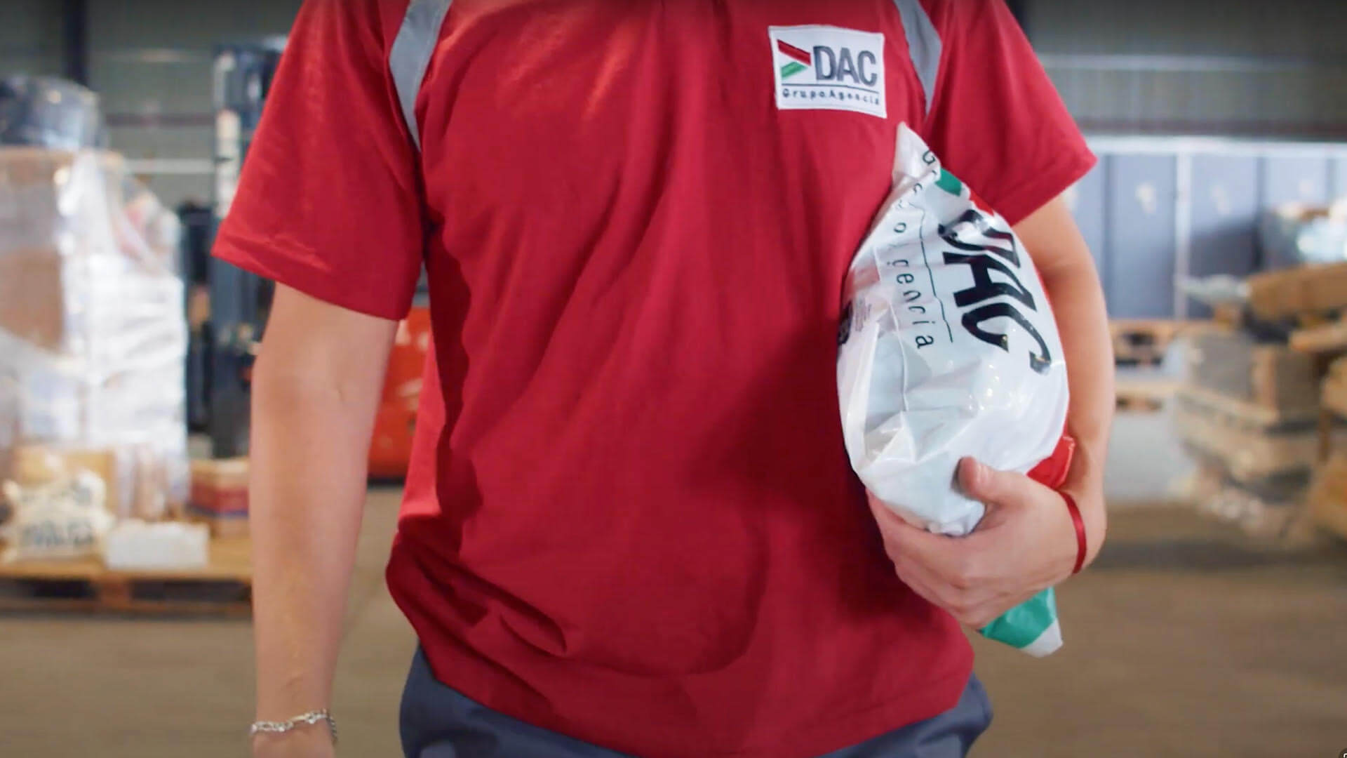 Empleado de DAC cargando un paquete dentro de la agencia